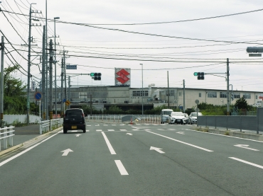 商業施設が進出すれば、渋滞が予想されるスズキ豊川工場前の道路=交差点「市民病院東」付近で