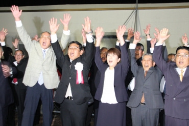 再選を果たし、バンザイする村上氏(前列左から2人目)と、としこ夫人(同3人目)=東栄町本郷で