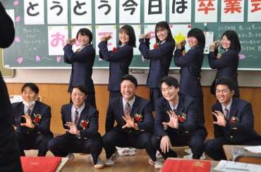 捕手のポーズで同級生と記念撮影する中川さん(前列中央)