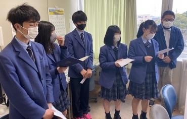 桜丘高校の修了式で全校生徒に対して平和宣言を読み上げる生徒会のメンバー