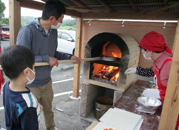 ピザ窯で体験する親子=いずれも新城市黒田のJAプラザで