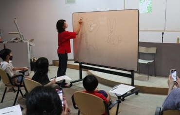 動物のイラストを描くかべやさん=豊川市中央図書館で