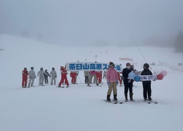 オープンしたスキー場。伊藤村長(前列中央)に向けたメッセージボードも=茶臼山高原スキー場で(提供)