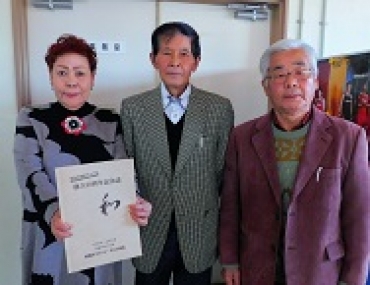 完成した30周年記念誌を披露する村松副会長、熊谷会長、牧副会長(右から)=岩田運動公園で