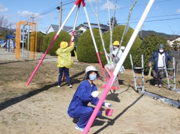 ブランコの支柱を塗る児童=新城市八名小学校で