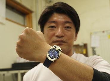 オオグソクムシ腕時計を着ける小林館長=竹島水族館で
