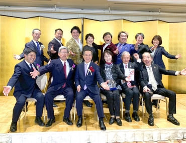 授賞式での記念写真。前列左から2人目が鈴木委員長。後列中央6人が駆けつけたキャスト=都内で(提供)