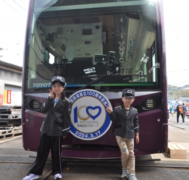 ほっトラムの前で記念撮影する子どもたち=赤岩口車庫で