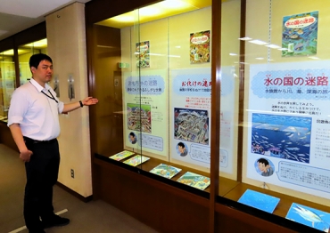 展示を紹介する岡村さん=豊橋市中央図書館で