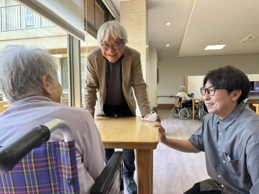 利用者と談笑する石原理事長㊧と石原王寿園施設長