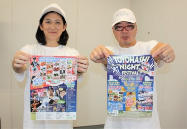 チラシを持って来場を呼び掛ける斎藤さんと妻の美由紀さん=豊橋市役所で