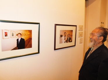 東松氏の写真を見る越知氏=同