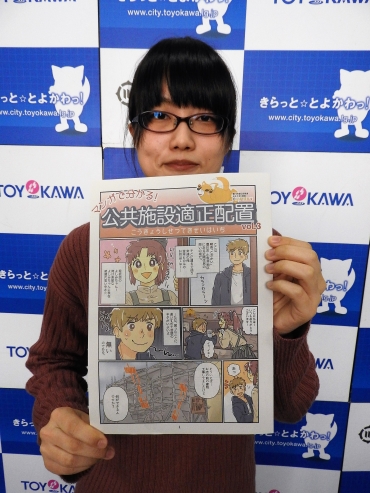漫画で公共施設の適正配置計画を説明した冊子をPRする木本さん=豊川市役所で