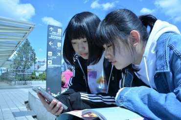 スマートフォンで新元号発表の瞬間を見る中学生=豊橋駅前で