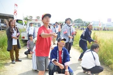 空中を見上げ、真剣な表情で糸を引く参加者=田原市内で