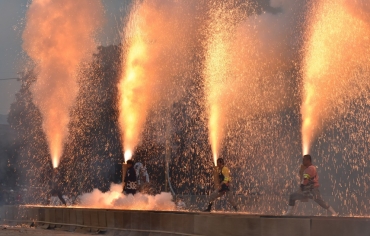 オレンジ色の火柱を噴き上げる、各連区の手筒煙火責任者による手筒の一斉放揚=豊川市野球場で