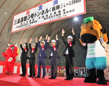 貫通点で万歳三唱する穂積市長㊨ら=新城市と東栄町境のトンネル内で