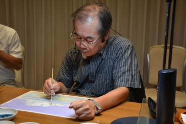背景画を描く山本氏=崋山会館で