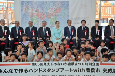披露されたアート作品の前に並ばれる瑶子さまと参列者たち=ここにこで