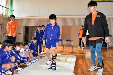 子どもらのスポーツ義足体験を見守る大島さん㊨=豊川小学校で