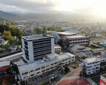 手前の2階建て建物が旧庁舎。大きさの違いが分かる=ドローンで撮影