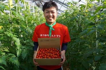 医療従事者に贈るミニトマトの箱を持つ小川さん=おがわ農園で
