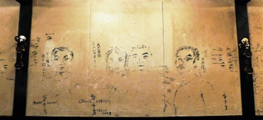 ミニハウスオーナー夫妻の似顔絵、松井さんの自画像などが描かれた壁面