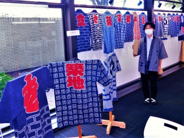 羽田祭参加町内法被とはんてんを紹介する山田主事