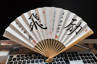 記念に贈られた井山名人㊨、一力天元のサイン入り扇子(同)