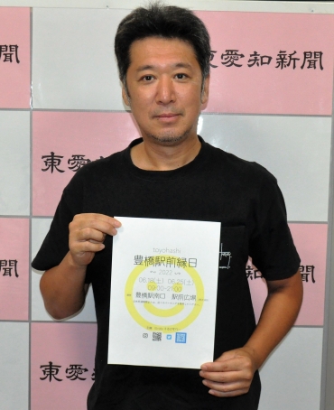 「お祭り気分で縁日を楽しんで」とチラシを持つ中村さん=東愛知新聞社で