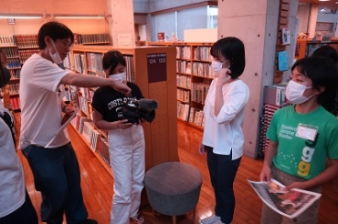 上田准教授㊧の手ほどきで撮影に挑戦する子どもたち=田原市中央図書館で