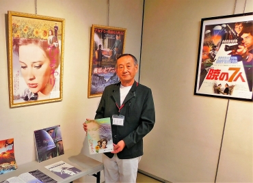 戦争映画のポスターを紹介する佐々木さん=豊橋市民文化会館で