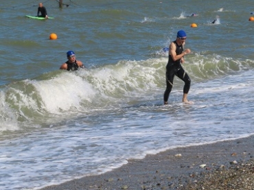 強い波に負けず周回を終える選手=白谷海浜公園で