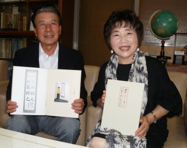 書道作品集「書とゝもに」を手にする小野田さん夫妻=東愛知新聞社で