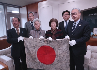 78年ぶりに帰ってきた日章旗を持つみなさん。前列右から浅井市長、式子さん、侑子さん、田中会長=豊橋市役所で