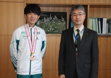 銅メダルを掛けて訪問した脇田さん㊧=新城市役所で