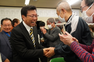 涙を流しながら支持者と握手する喚田氏の事務所で午後10時35分