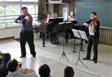 児童らを前に、クラシック曲を奏でる(左から)平光さん、菅原さん、新谷さん=桜木小学校で