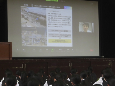 オンラインで講演する井上さん(スクリーン右側)=成章高校で