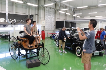展示車両で記念撮影する見学ツアーの参加者=メルセデス・ベンツ日本「豊橋VPC」で