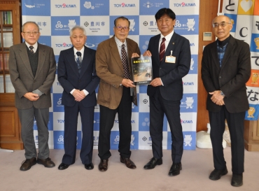 豪雨災害記録誌を竹本市長へ渡す鈴川さん(左から3人目)=豊川市役所で