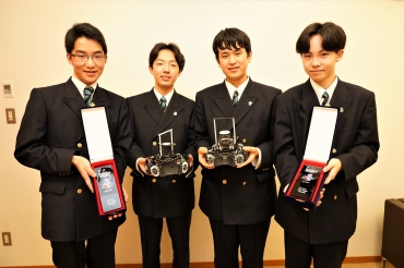 トロフィーと出場したロボットを持つ加藤さんと石川さん、高橋さん、野木森さん(左から)=海陽中等教育学校で