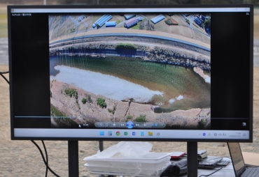 ドローンが上空から撮影した河川の映像をモニターで表示