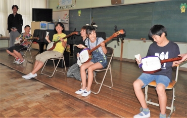 三絃士の助言で、津軽三味線の演奏を楽しむ子どもたち=御津南部小で
