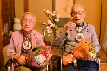 年齢の書かれた“メダル”を掛けて106歳の誕生会に出た白井さんとすわ子さん=豊橋市札木町の日本料理店「みなと」で
