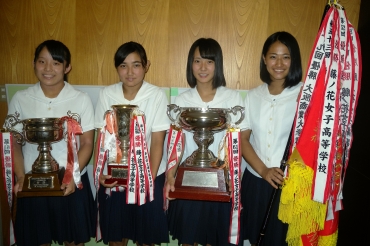 優勝旗やカップをを手に笑顔の(右から)尾藤さん、中山さん、鈴木さん、塩谷さん=東愛知新聞社で