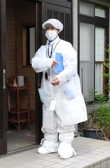 放射能から身を守る防護服で浪江町の自宅に一時帰宅する一条さん(昨年6月写す)