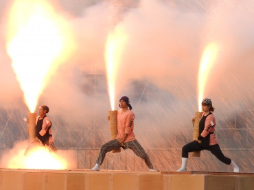 オレンジ色の火柱を噴き上げる手筒を抱える参加者=豊川市野球場で