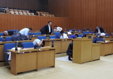 地震発生の知らせを受け、議席の下に潜り込む議員ら=豊川市議場で