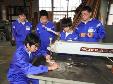 機械で木材の加工に臨む中学生ら=東三河高技専で